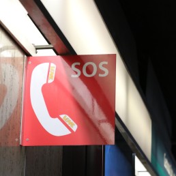 a red sign hanging from the side of a building